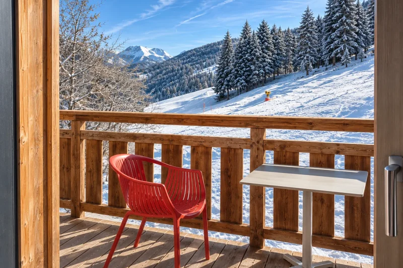 Le balcon d'une chambre, face aux pistes enneigées